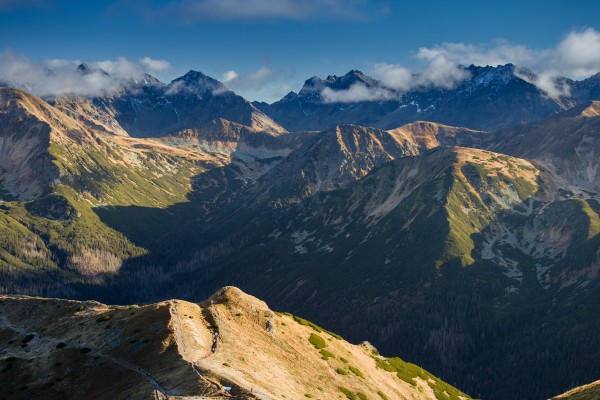 a mountain range with clouds and blue sky